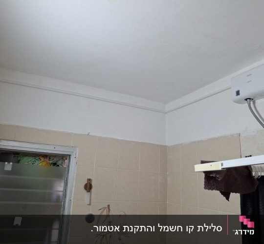 מכשיר אטמור לחימום מים מהיר מותקן על קיר בחדר רחצה